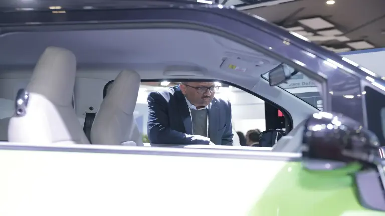 Ein Mann schaut in ein Auto, das am Bosch-Stand auf einer Messe ausgestellt ist.