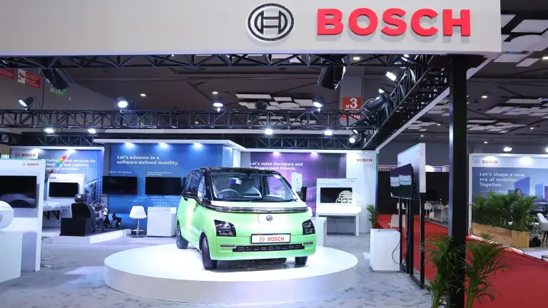 Ein kleines, grünes Fahrzeug ist auf einem Podium am Bosch-Stand auf der BMGE ausgestellt.