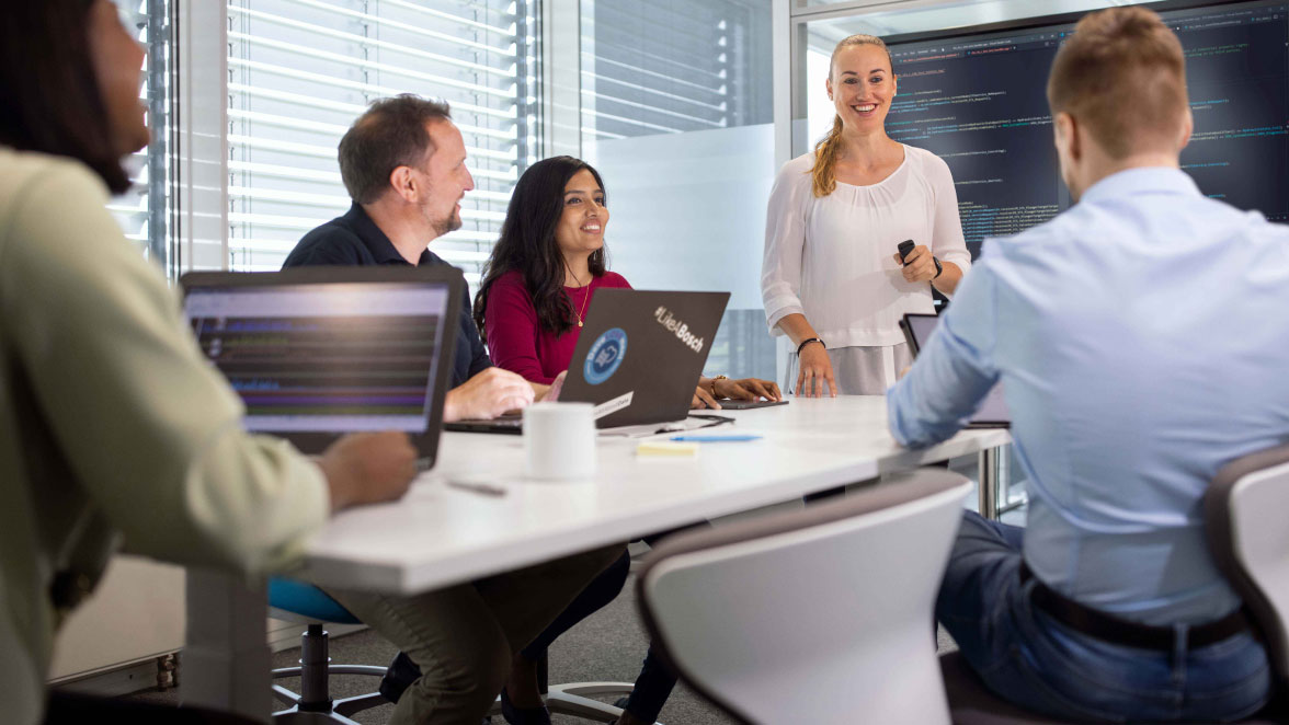 A team of developers in a conference room during a meeting.