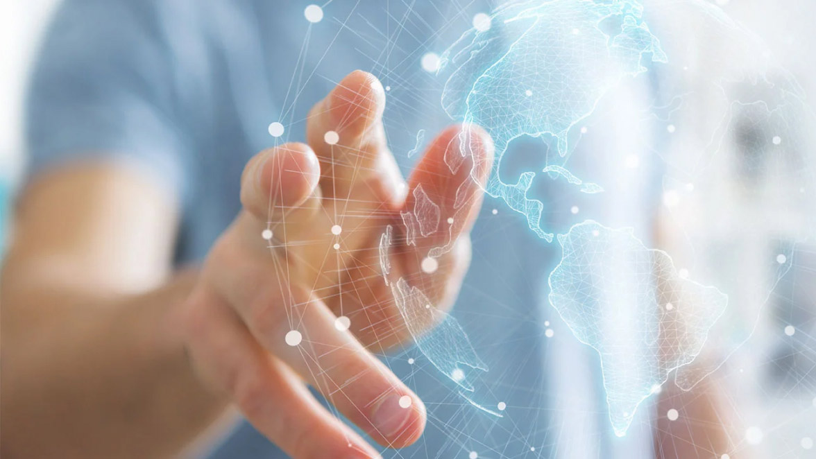 Close-up of a hand pointing to a holographic globe